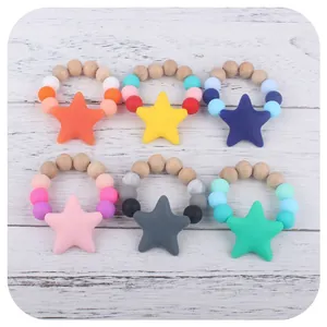 Set of 6 silicone and beech wood baby star teethers in various pastel colors on wood background