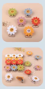 Macro shot of handmade crochet sunflower clips with smiling faces in various pastel colors