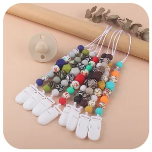 Christmas silicone pacifier clip set with colorful beads and pacifiers on wooden display