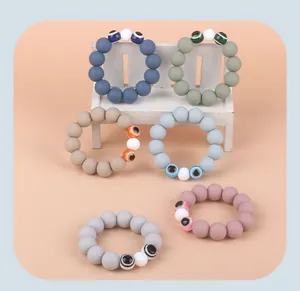 Detail of silicone teething bracelets with evil eye beads and matte colorful textures