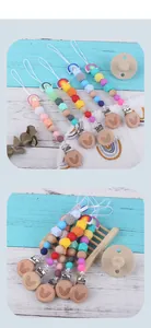 Close-up of rainbow silicone and wooden bead pacifier clips set on a rustic wooden stand