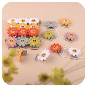 Handmade crochet sunflower pacifier clips in various vibrant colors with embroidered smiles