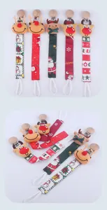 Detailed view of assorted Christmas pacifier clips with reindeer plush and festive ribbons