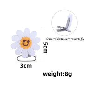 Crochet sunflower pacifier clip with smiley face and serrated metal clamp for babies