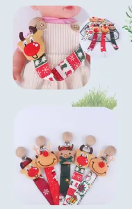 Detail of Christmas reindeer pacifier clips with festive ribbon patterns and wooden clips