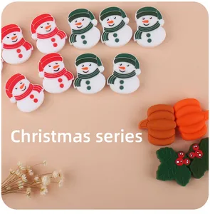 Close-up of festive Christmas silicone beads featuring snowmen and holly leaf designs
