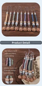 Detail showing silicone and wooden beads of the pacifier clip on a rustic background