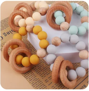 Detail of wooden rings and silicone beads infant sensory teether on newspaper background
