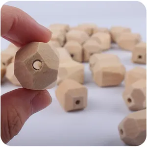 Hand holding 18mm geometric multifaceted wood bead for DIY pacifier clips and teething jewelry
