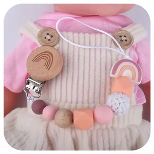 Rainbow silicone and beech wood baby pacifier clip with crochet beads on infant clothing