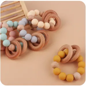 Detailed close-up of macaron silicone beads and natural wooden rings on baby teething bracelets