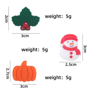 Detailed view of Christmas silicone beads including snowman and holly icons for DIY pacifier clips