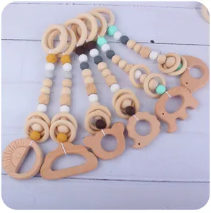 Detail view of five wooden baby teethers with sun, bear, and elephant shapes