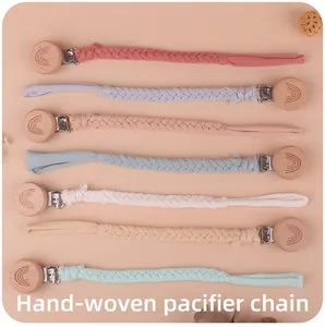 Detail view of seven hand-woven cotton pacifier chains with rainbow engraved wooden clips