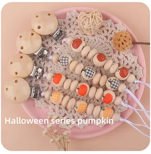 Detalle de sujetachupetes de madera Halloween con cuentas de calabaza y cuadros negros