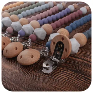 Handmade silicone and beech wood baby pacifier clips in various Morandi colors