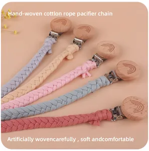 Macro detail of handmade cotton pacifier clips with rainbow engraved beech wood clip