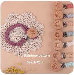 Detail of beech wood pacifier clip with rainbow engraving and soft woven cotton strap