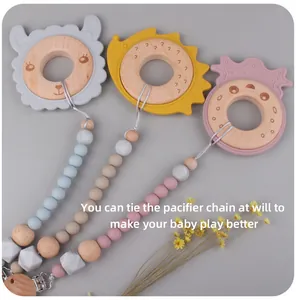 Detail of wooden animal teether ring and silicone pacifier clip in three soft colors