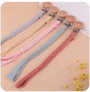 Detail of handmade cotton woven pacifier clips with engraved rainbow beech wood