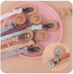 Detail of wooden pacifier clip featuring rainbow engraving and fabric-friendly plastic teeth
