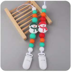 Close-up of silicone beaded pacifier clips with festive snowman and colorful beads