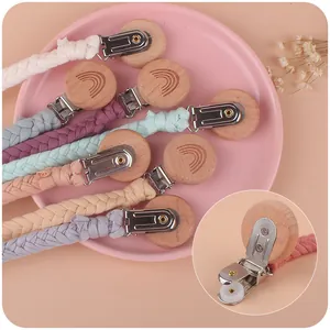 Handmade woven cotton pacifier clip with rainbow wooden metal fastener in pink dish