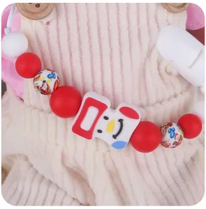 Detail of Christmas themed silicone pacifier clip with snowman bead and safety plastic clip