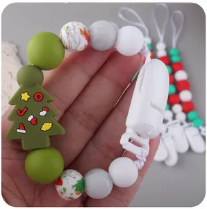 Close-up of silicone baby pacifier clip with Christmas tree and snowman beads detail