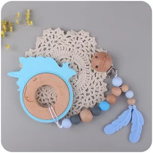Unicorn baby teether ring set with wooden beads and silicone clip on soft grey background