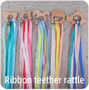 Detail of wooden animal teethers with colorful ribbons and small metal bells