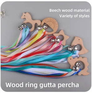 Macro shot of smooth beech wood baby teethers with colorful ribbons and metal bells