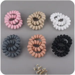 Close-up of 6 pairs of matte spiral hair ties in Morandi colors with dried flower decor