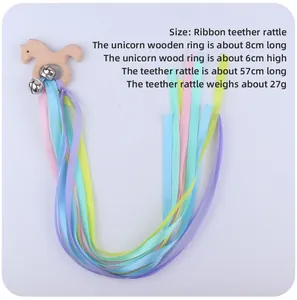 Detailed view of baby unicorn beech wood teether ring with colorful ribbons and bells