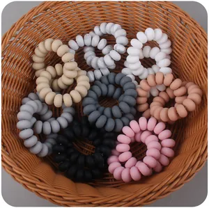 Detail view of multi-color spiral hair ties in a natural woven basket setting