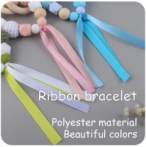 Detail of baby ribbon bracelet with wooden beads and colorful crochet textures