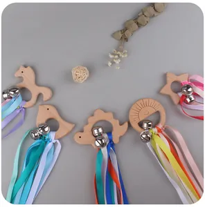 Detail view of baby beech wood teethers with colorful ribbons and small metal bells
