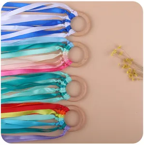Close-up of four beech wood sensory ribbon rings for infant motor skill development