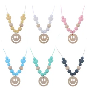 Detail view of baby sensory necklaces with wooden smile pendants and colorful silicone beads