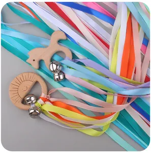 Close-up of wooden pony teether with colorful satin ribbons and metal bells