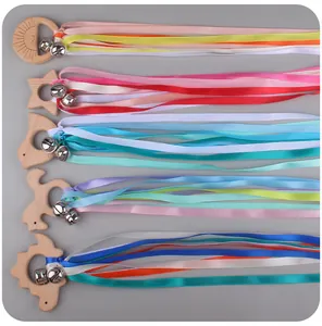 Detail view of five wooden baby rattles with colorful ribbons and small metal bells