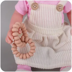 Baby silicone teething bracelet with beige beads worn by a doll for infant soothing