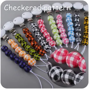 Detail view of checkered pattern beads and plastic clips for baby pacifier chains