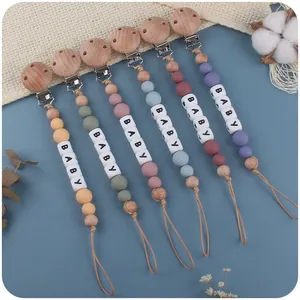 Detail von Baby-Schnullerketten aus Holz und Silikon mit BABY-Buchstabenperlen in sechs Farben