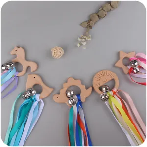 Natural beech wood teething rings with colorful ribbons and bells in animal shapes