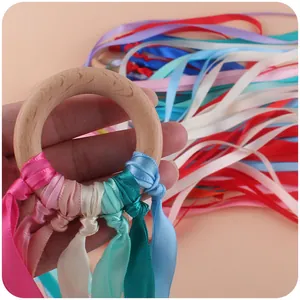 Handcrafted beech wood teething ring with colorful silk ribbons for baby sensory play