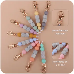 Detail view of 9 pastel silicone beaded keychains with gold metal hooks and marble textures
