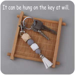 Detail of DIY beaded keychain with silicone beads, wooden bead, and a white tassel fringe