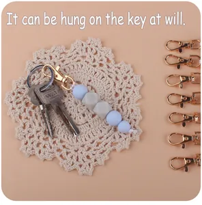 Detail showing silicone beads keychain with golden clasp attached to metal keys