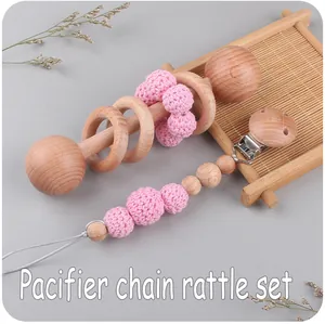 Close-up of pink crochet beads and natural beech wood pacifier chain and rattle set